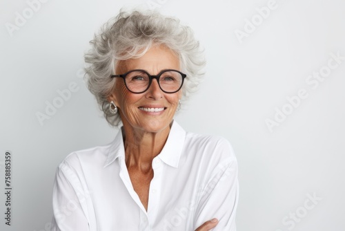 Portrait of happy senior woman in eyeglasses smiling at camera