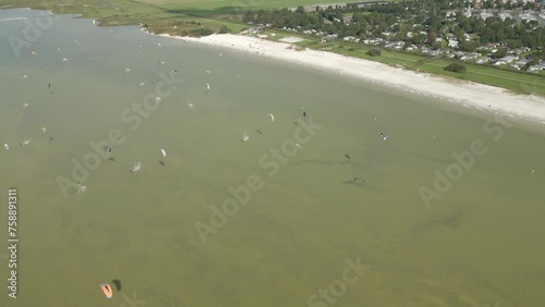 Aerial view of people doing kite surfing along the beach sunny day, Netherlands