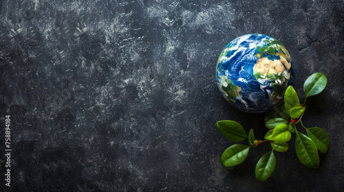 A symbolic representation of the planet Earth adorned with vibrant green leaves on a finely textured dark surface, invoking a sense of environmental stewardship photo
