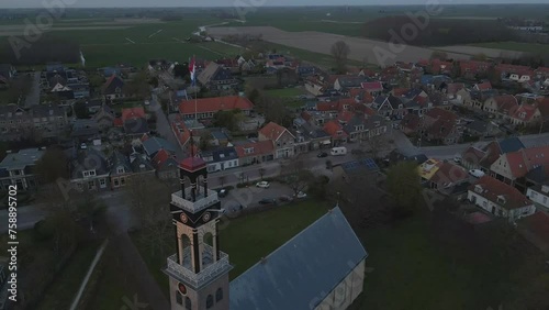 Aerial view of catholic church (Lambertuskerk) with dutch flag during sunset, Arum, Friesland, Netherlands photo