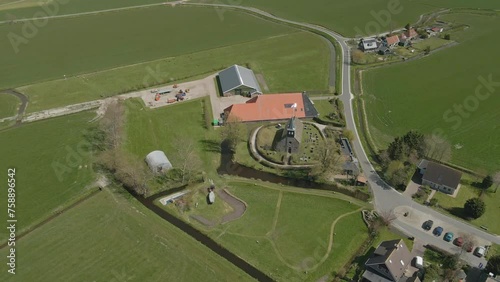 Aerial view of catholic church surrounded by farms in meadow, hieslum, Friesland, Netherlands photo