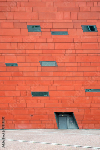 Architectural detail of red facade with windows, building exterior pattern