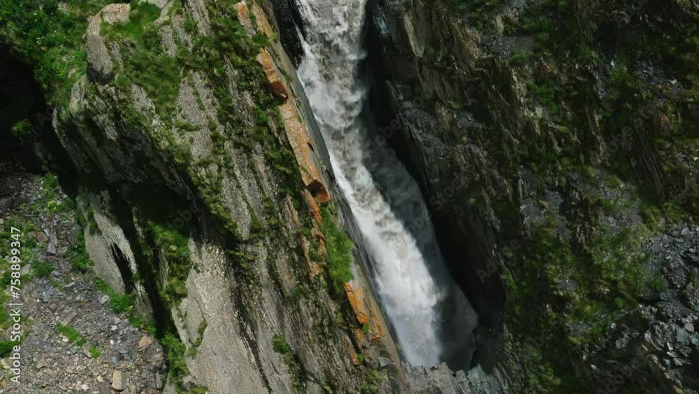 Bird's Eye View of a Waterfall Carving Through Moss-Covered Cliffside into a Rocky Basin Bird's Eye View of a Waterfall Carving Through Moss-Covered Cliffside into a Rocky Basin
