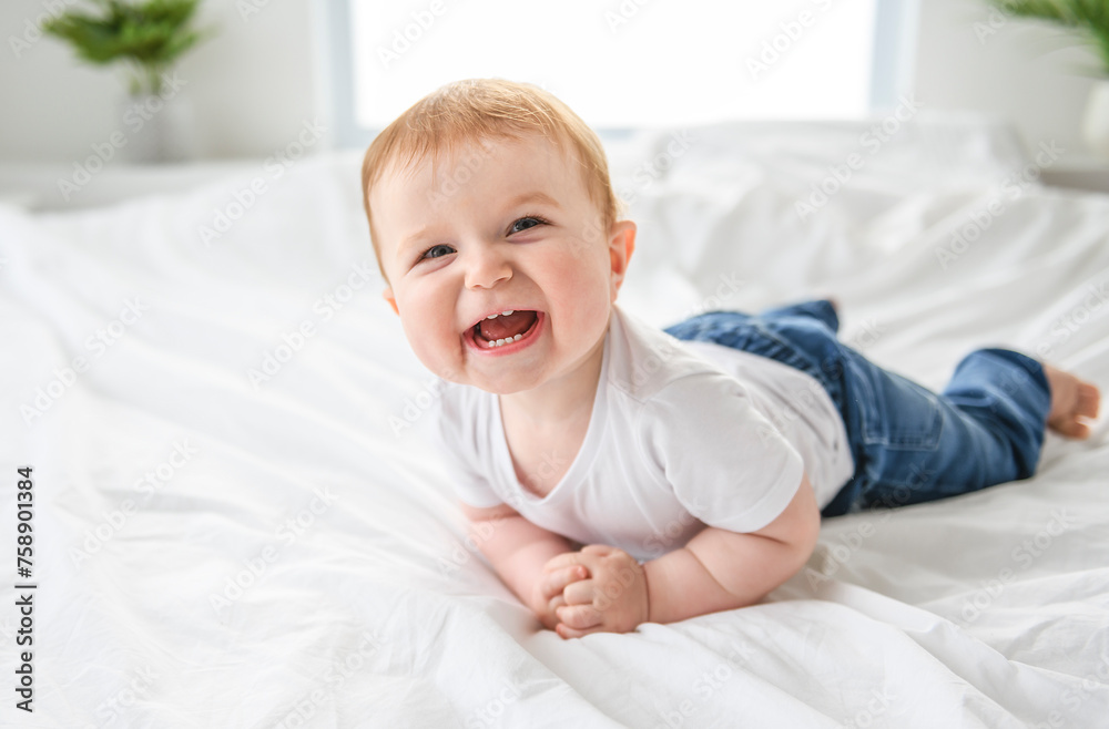 Baby boy in white sunny bedroom. one years child relaxing in bed. Baby boy in white sunny bedroom. one years child relaxing in bed.