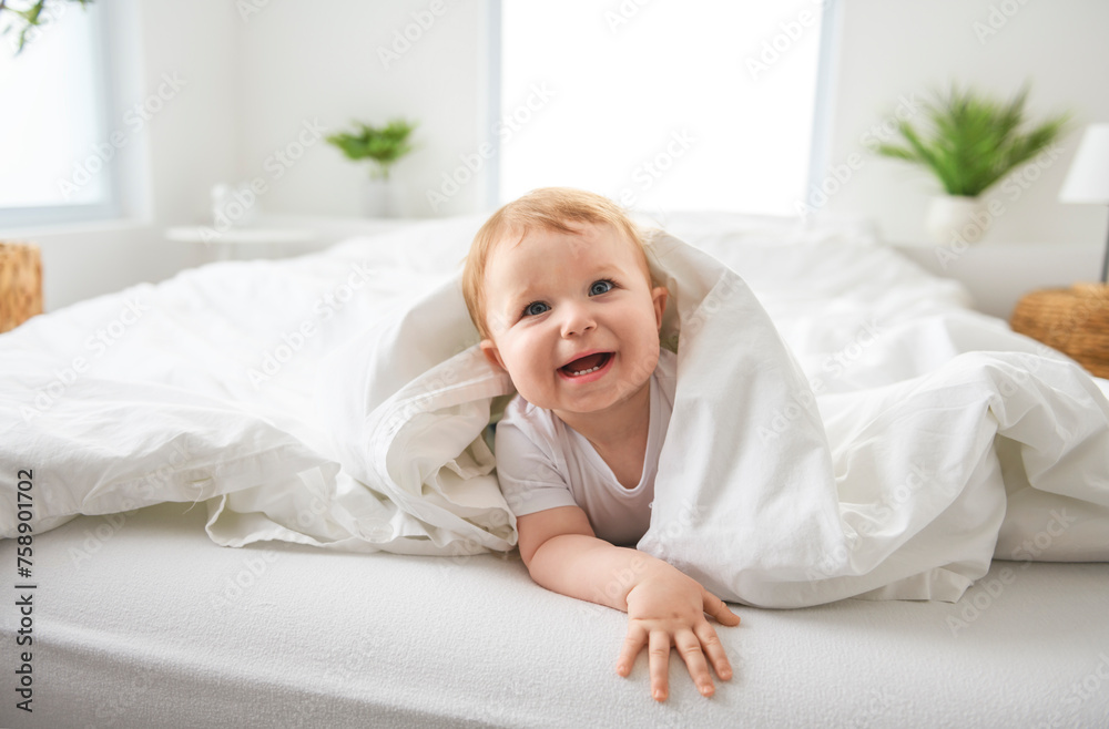 Baby boy in white sunny bedroom. one years child relaxing in bed. Baby boy in white sunny bedroom. one years child relaxing in bed.
