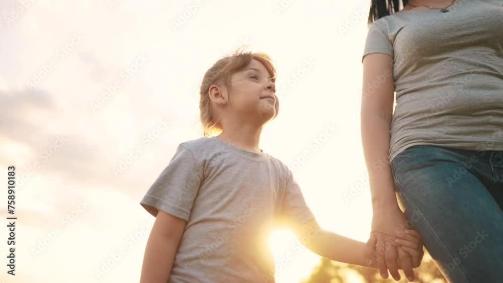 mother daughter walking in the park. happy family kid dream concept. close-up daughter holding her mother hand sun walking along the road in the park in nature. mom daughter outdoors in the park mother daughter walking in the park. happy family kid dream concept. close-up daughter holding her mother hand sun walking along the road in the park in nature. mom daughter outdoors in the park
