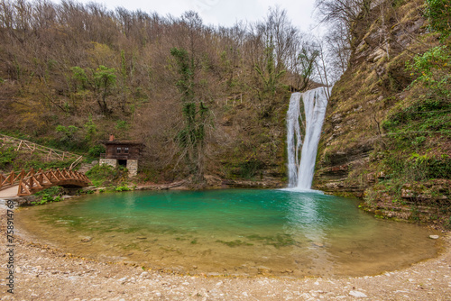 The idea of being in nature and the waterfall flowing through the trees decorated with autumn colors the rocks calmness peace and happines