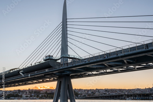 metro bridge located on the golden horn of istanbul golden horn with sunset light buildings and balat district in the background photo