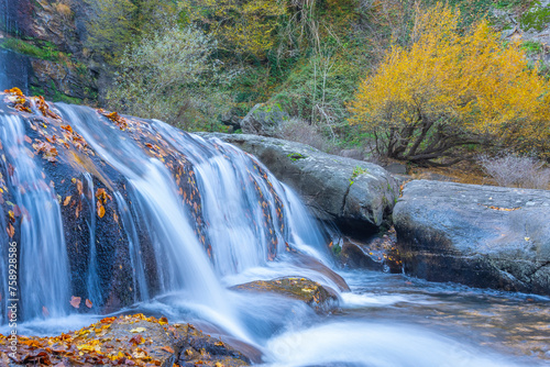 The idea of being in nature and the waterfall flowing through the trees decorated with autumn colors the rocks calmness peace and happiness