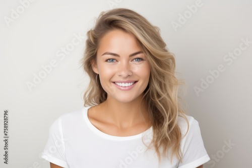 Portrait of a beautiful young blond woman smiling and looking at camera