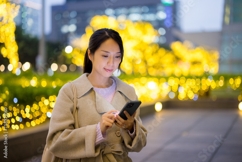 Young woman use mobile phone in Taipei city at night