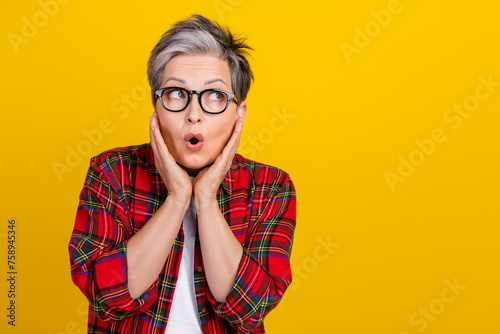 Photo of impressed confused person arms touch cheekbones look empty space information isolated on yellow color background