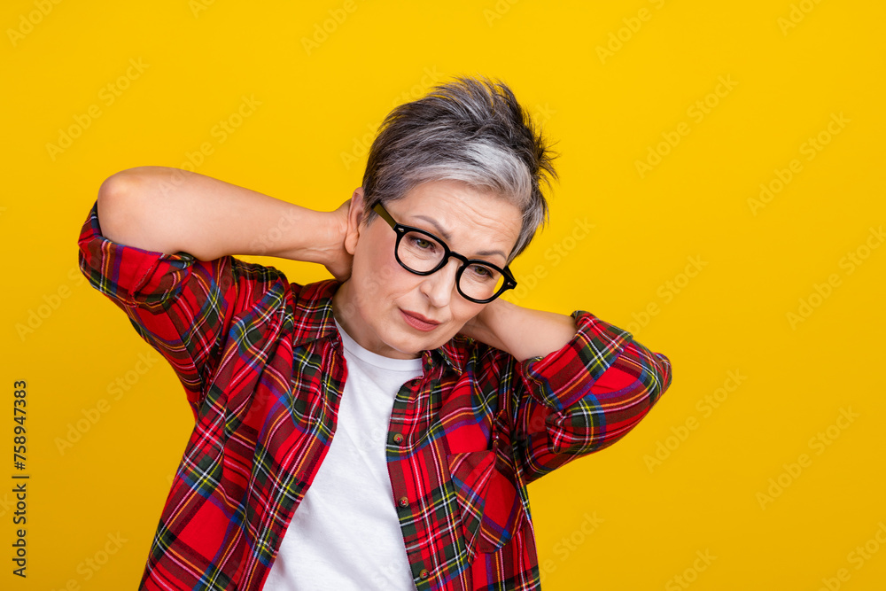 Photo of unsatisfied aged person hands touch neck suffer pain empty space isolated on yellow color background Photo of unsatisfied aged person hands touch neck suffer pain empty space isolated on yellow color background