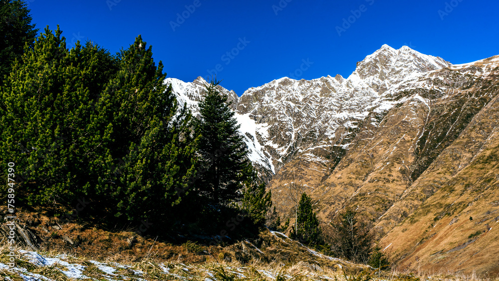 Snow-capped mountains with winding roads and rocky cliffs