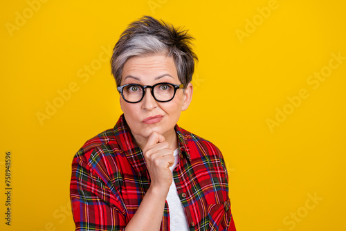 Portrait of pensive doubtful aged person hand touch chin brainstorm empty space isolated on yellow color background