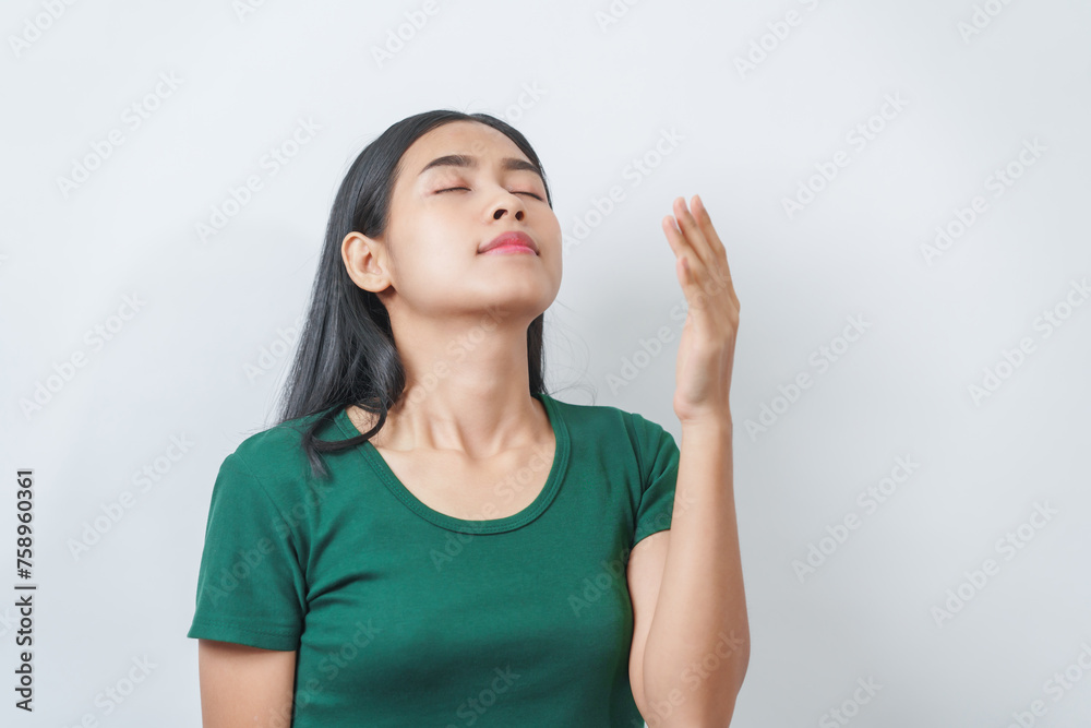 Happy and calm Asian girl is seen enjoying a pleasant aroma, taking deep breaths of fresh air in isolation. Happy and calm Asian girl is seen enjoying a pleasant aroma, taking deep breaths of fresh air in isolation.