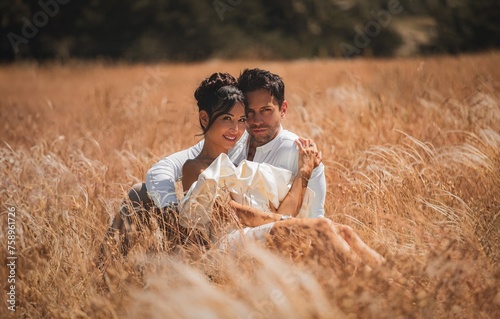 A stunning married couple embraces alidst a golden wheat field at sunset. Perfect romantic-themed  © rdrgraphe