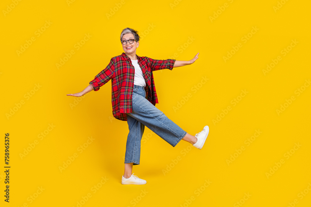 Full length profile photo of cheerful pretty lady chilling dancing empty space isolated on yellow color background