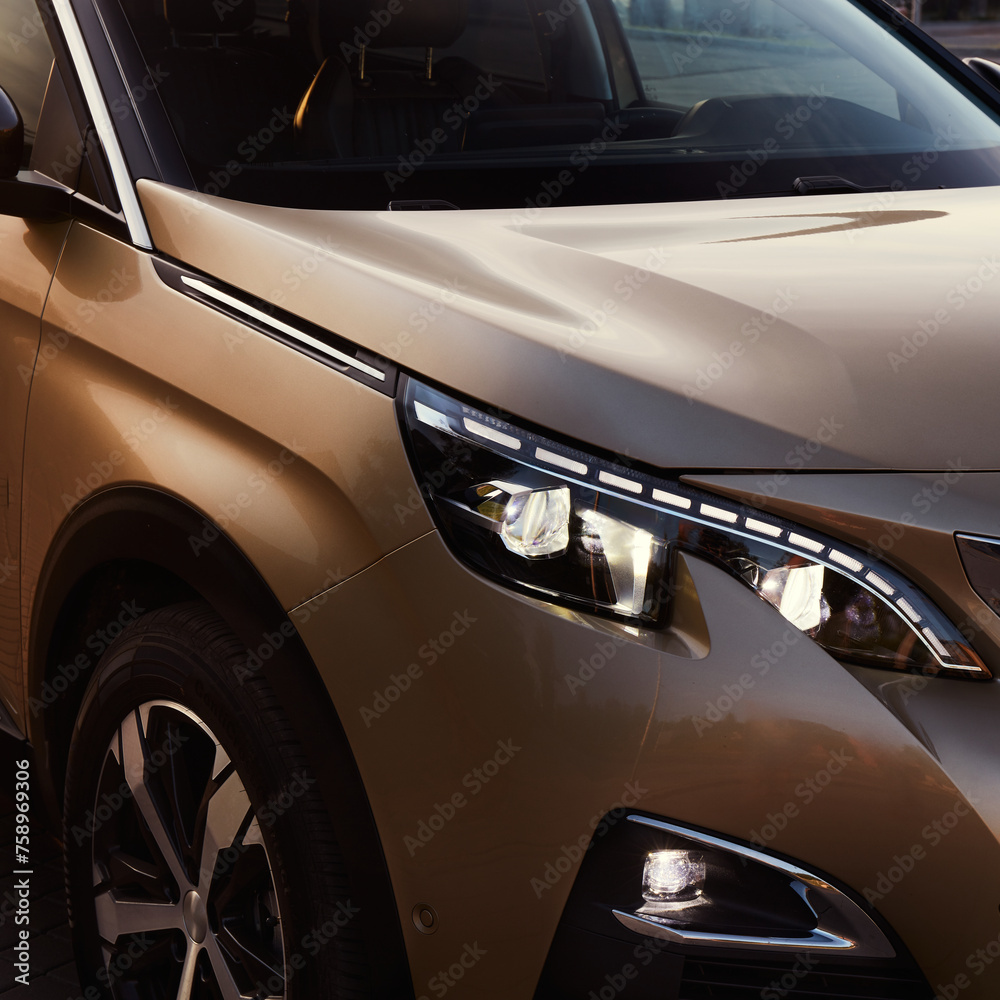 Golden SUV by sunset. Close up of the headlights.