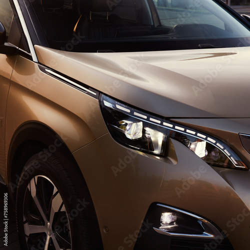 Golden SUV by sunset. Close up of the headlights. © Artur Nyk