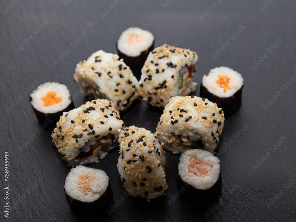 Sushi hosomaki with boiled carrots, raw salmon and sushi futomaki with surimi, carrots, pepper and melted cheese Sushi hosomaki with boiled carrots, raw salmon and sushi futomaki with surimi, carrots, pepper and melted cheese