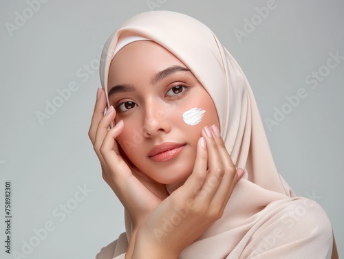 hijab of beauty woman applying cream on face