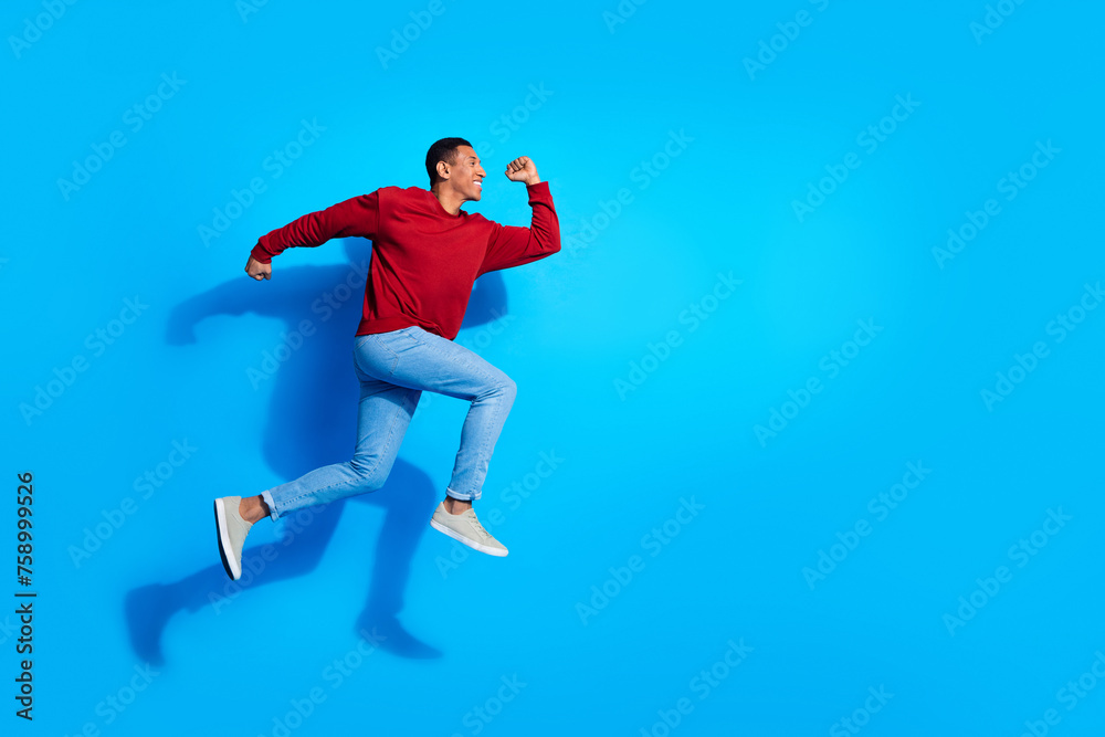 Full body profile photo of cheerful energetic person jump run empty space isolated on blue color background
