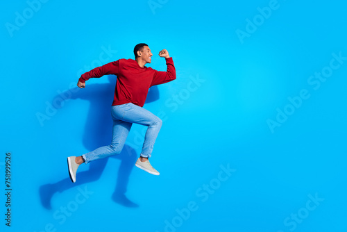 Full body profile photo of cheerful energetic person jump run empty space isolated on blue color background