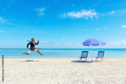 Happy businessman running from the work on the tropical beach. Summer vacation concept. photo