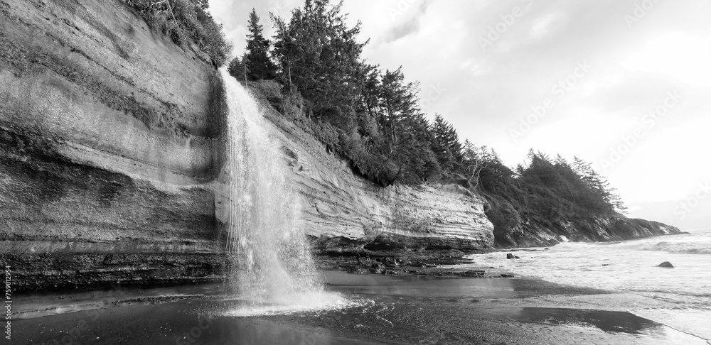 Waterfall shooting out of the rain forest atop cliffs at Mystic Beach. Vancouver Island, Canada