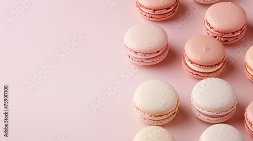 A minimalist arrangement of pastel-colored macarons on a soft blush pink surface