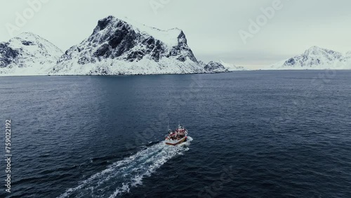 Fishing boat heading out towards the open ocean on a beautiful cold winter day,