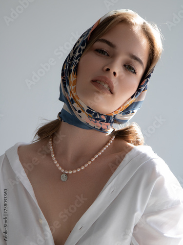 fashion photo of beautiful young woman looking like elegant lady. Beautiful girl, fashion and beauty. White shirt and scarf, French style. Clean skin and daytime makeup. Lovely model