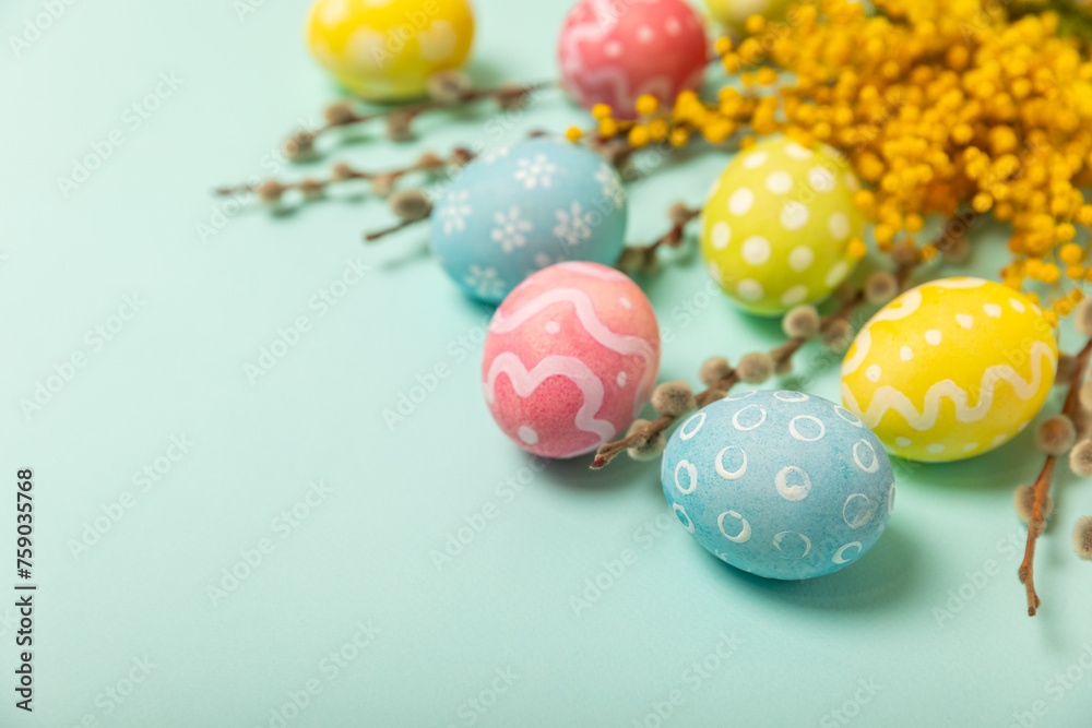 Easter eggs with mimosa flowers on a bright background. Easter celebration concept. Colorful easter handmade decorated Easter eggs. Place for text. Copy space. Easter eggs with mimosa flowers on a bright background. Easter celebration concept. Colorful easter handmade decorated Easter eggs. Place for text. Copy space.