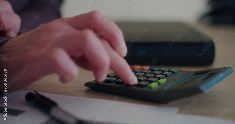 Hand of senior businessman calculating budget at desk Hand of senior businessman calculating budget at desk