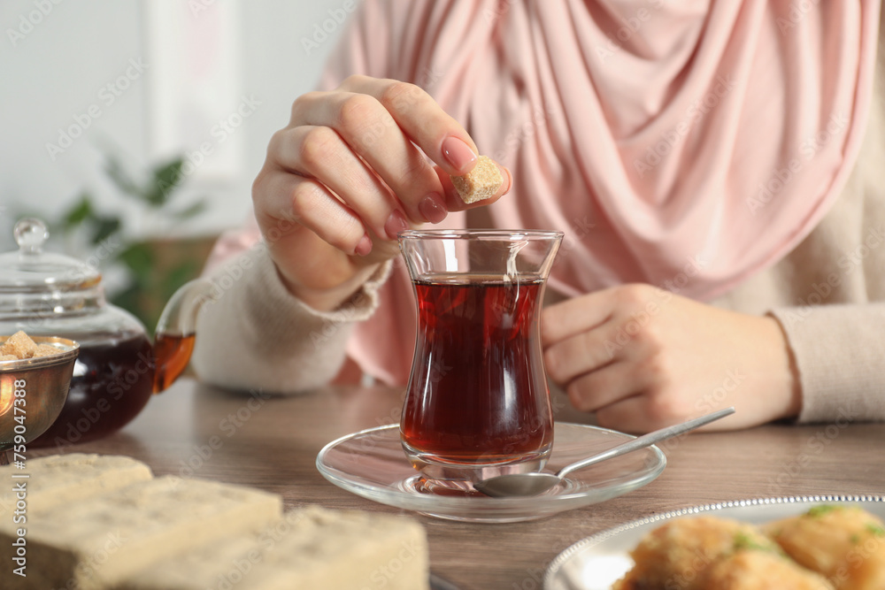 Woman with cup of delicious Turkish tea at wooden table, closeup Woman with cup of delicious Turkish tea at wooden table, closeup