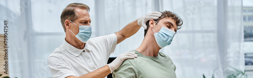 Принти на полотні mature appealing doctor with gloves and mask helping to rehabilitate his patient