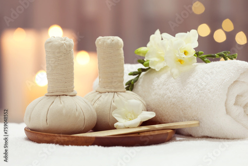 Beautiful composition with different spa products and flowers on white towel against blurred background  closeup