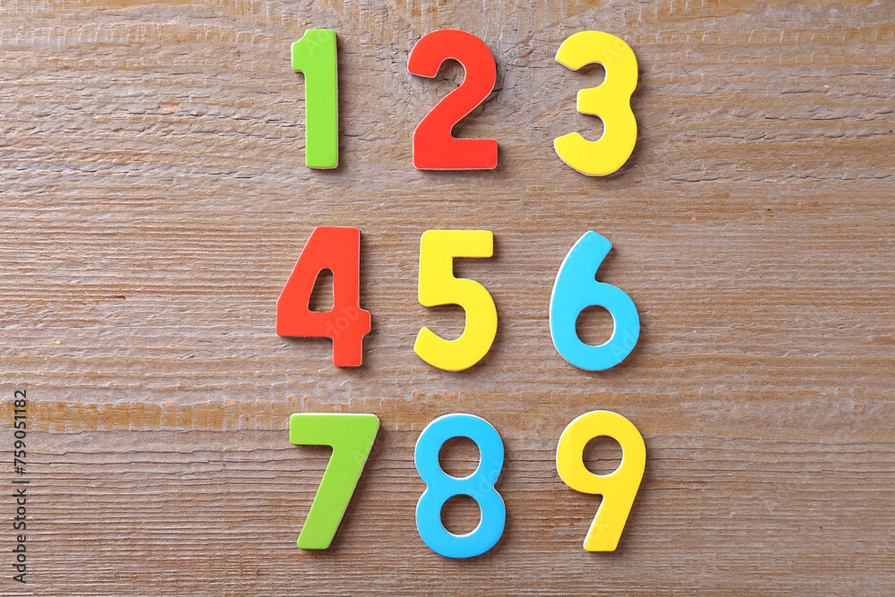Naklejka premium Colorful numbers on wooden table, flat lay