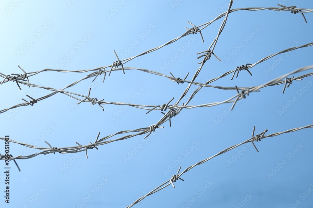 Metal barbed wire on light blue background Metal barbed wire on light blue background