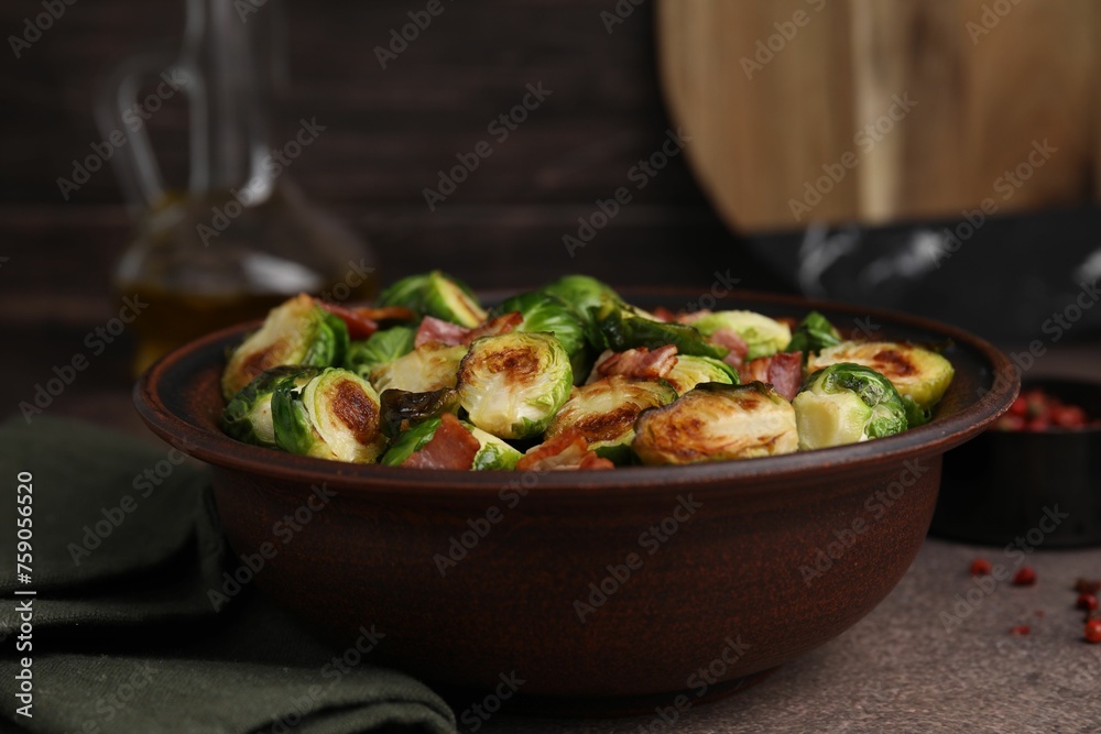 Delicious roasted Brussels sprouts and bacon in bowl on brown table, closeup Delicious roasted Brussels sprouts and bacon in bowl on brown table, closeup