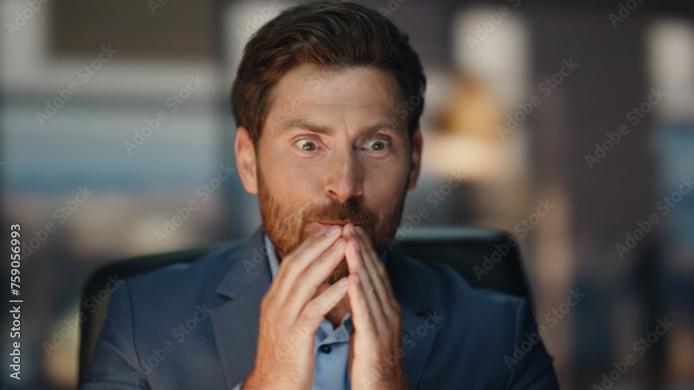 Cheerful man raising hands at night coworking closeup. Businessman saying wow Cheerful man raising hands at night coworking closeup. Businessman saying wow
