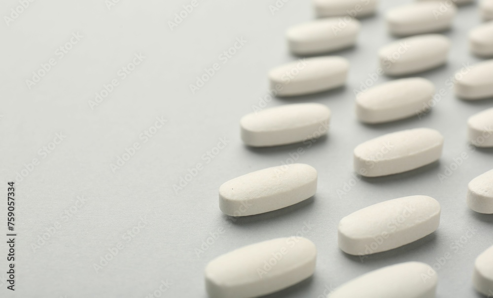 Vitamin pills on light grey background, closeup with pace for text. Health supplement Vitamin pills on light grey background, closeup with pace for text. Health supplement