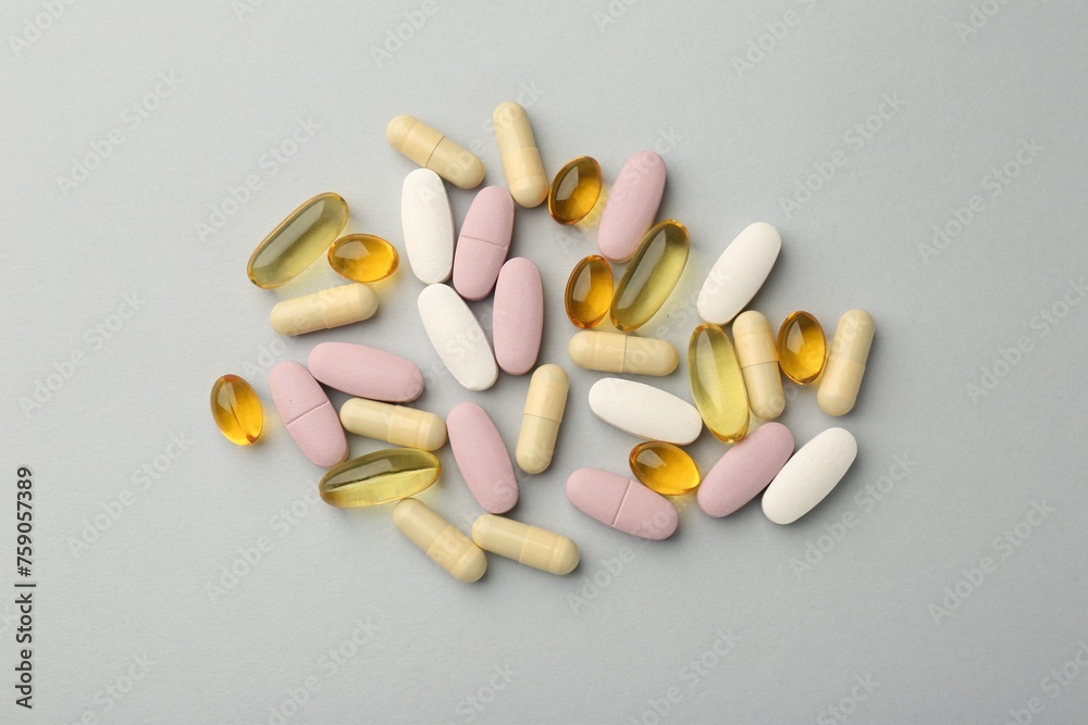 Different vitamin pills on light grey background, top view. Health supplement Different vitamin pills on light grey background, top view. Health supplement