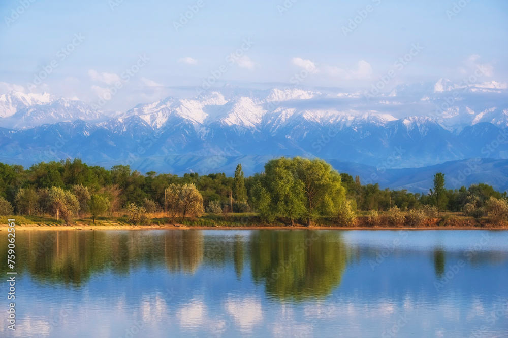 Lake near high snowy mountains in summer with a beautiful reflection