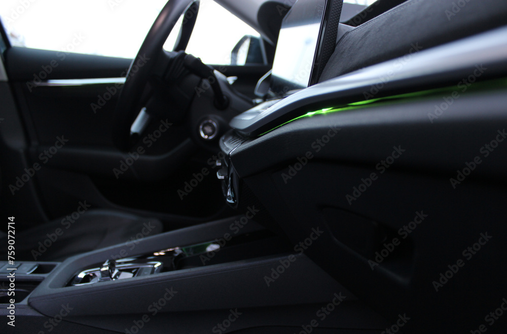 Green LED interior backlight on the front panel and dashboard inside the car side view from passenger seat 