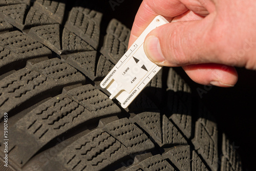 close-up of measuring tread depth of car tire