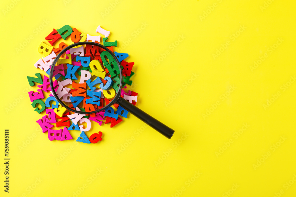 colored letters of the alphabet with a magnifying glass on a yellow background colored letters of the alphabet with a magnifying glass on a yellow background