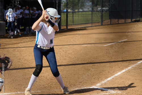Photography Young female Softball player playing youth sports. Swinging bat.