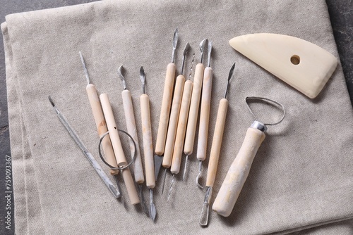 Set of different clay crafting tools on grey fabric, top view